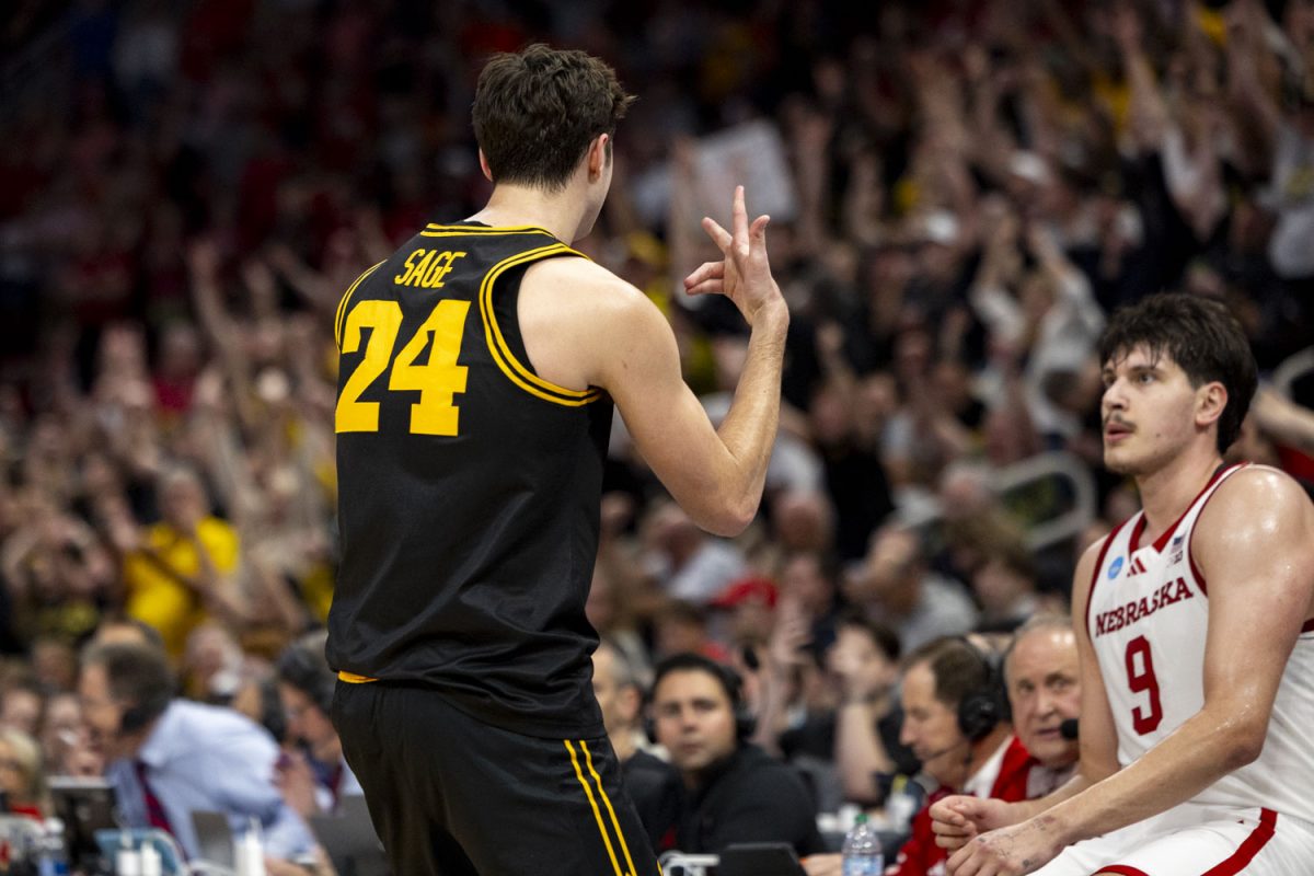 Iowa guard Tate Sage celebrates as Nebraska forward Berke Büyüktuncel watches during a basketball game between the No. 9 seed Iowa Hawkeyes and the No. 4 seed Nebraska Cornhuskers at the Toyota Center in Houston, Texas on Thursday, March 26, 2026. The Hawkeyes defeated the Cornhuskers, 77-71. (Samantha DeFily/The Daily Iowan)