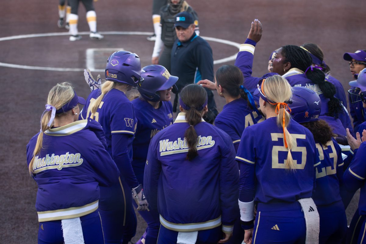 Washington celebrates catcher Jadyn Glab after she hit a home run at the softball game between Iowa and No. 16 Washington on Friday, March 27, 2026. Glad had a home run to bring Washington into the lead, along with vain six putouts with an assist as catcher. The Huskies handed the Hawks their biggest defeat of the season so far with a 16-7 win over Iowa. (Travis Crabb/The Daily Iowan)