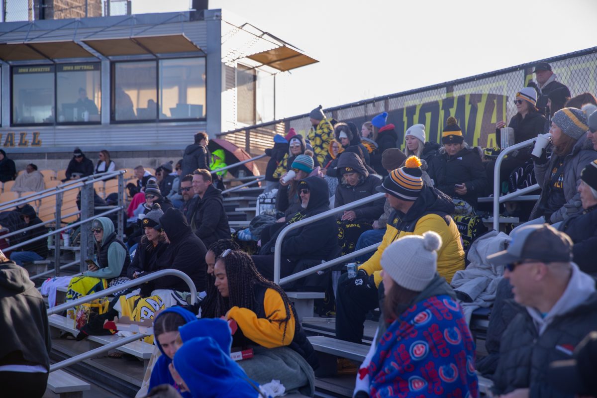 Fans in the stands bundled up against the cold before the softball game between Iowa and No. 16 Washington on Friday, March 27, 2026. This is the third series at Bob Pearl Field for the Hawkeyes this season. The Huskies handed the Hawks their biggest defeat of the season so far with a 16-7 win over Iowa. (Travis Crabb/The Daily Iowan)
