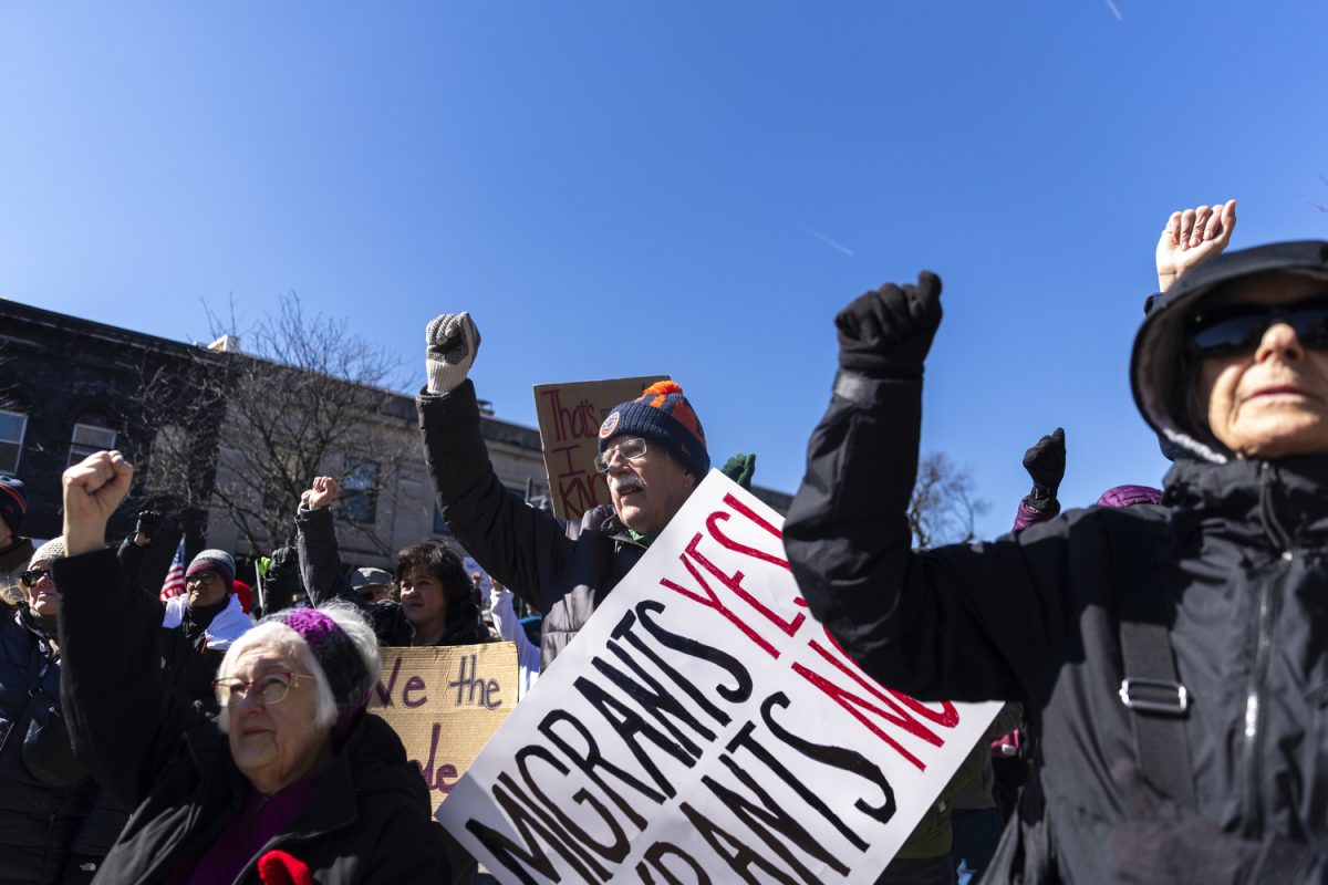 Protesters raise their fist during a “No Kings” protest in downtown Iowa City on Saturday, March 28, 2026. The Iowa City demonstration is part of protests taking place nationwide against President Donald Trump’s  administration, ICE, and the war in Iran. (Gabby Drees/The Daily Iowan)