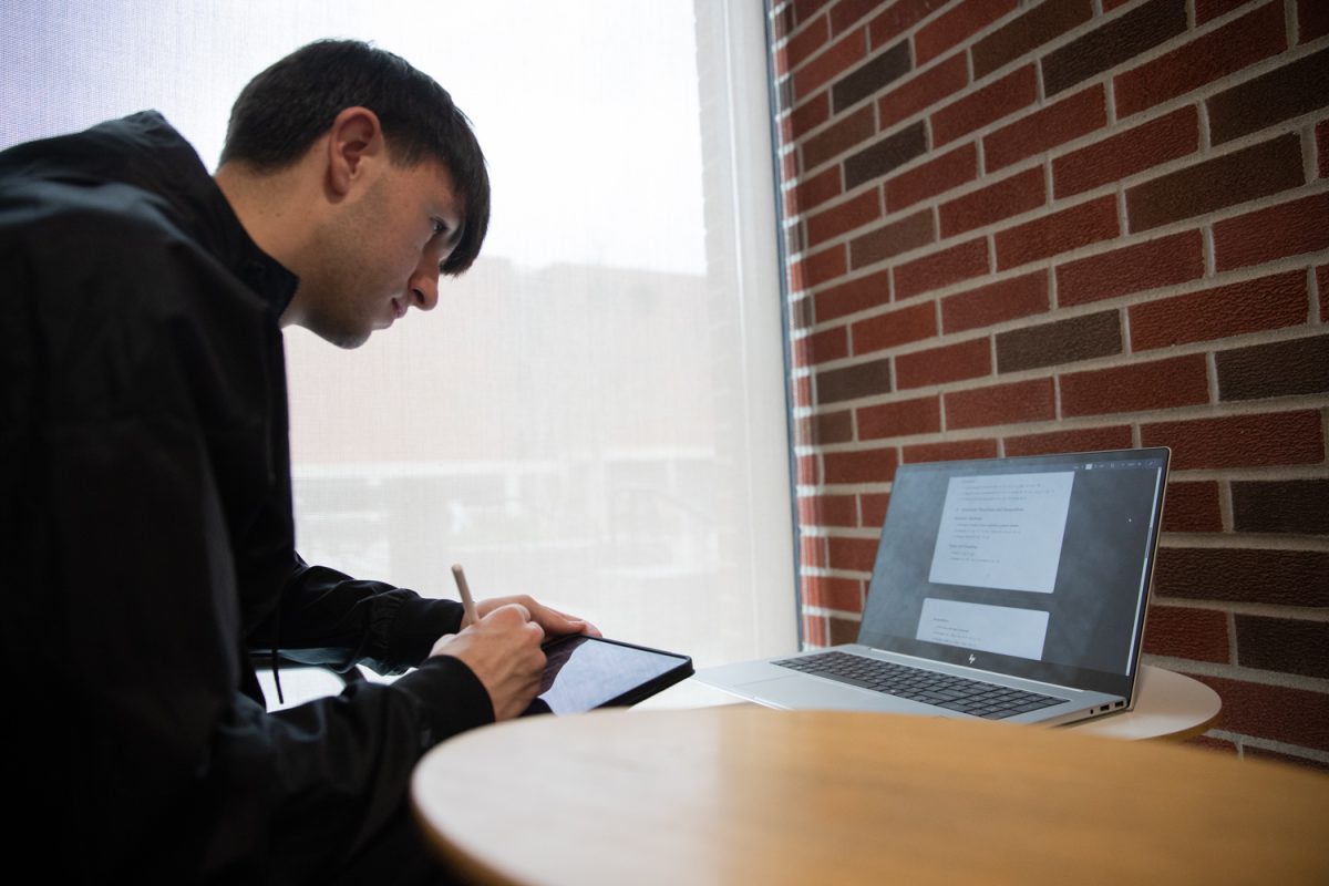 University of Iowa student Nathan Butler finds things to keep him busy during a break between classes, on Friday, Mar. 6, 2026. Nathan has on average two breaks between classes a day. (Dexter Westbay/The Daily Iowan)