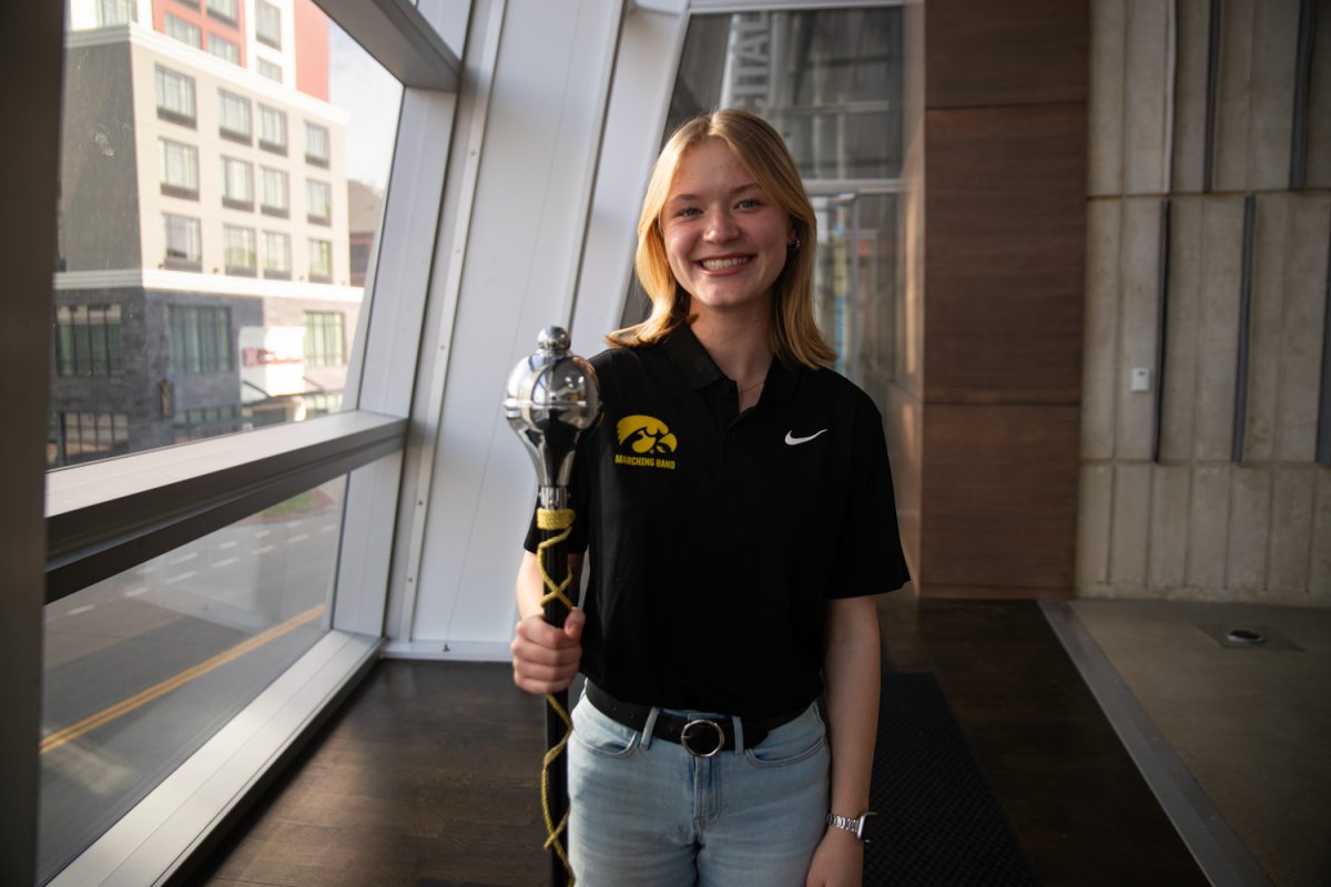 Annabelle Temple poses for a photo with her  mace at the Voxman Music Building on Monday, April 6, 2026. Temple was named the next drum major for the Hawkeye Marching Band after two years playing clarinet. Temple is a sophomore from Illinois. (Ava Neumaier / The Daily Iowan)