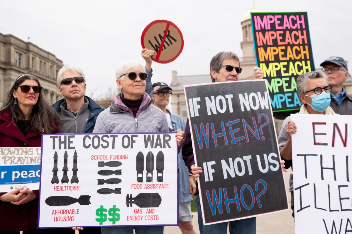 Protesters hold signs and listen to speakers during an Indivisible anti-genocide protest on the University of Iowa Pentacrest in Iowa City on Thursday, April 9, 2026. Protesters gathered to speak out against President Trump and the war in Iran. (Ethan McLaughlin/The Daily Iowan)