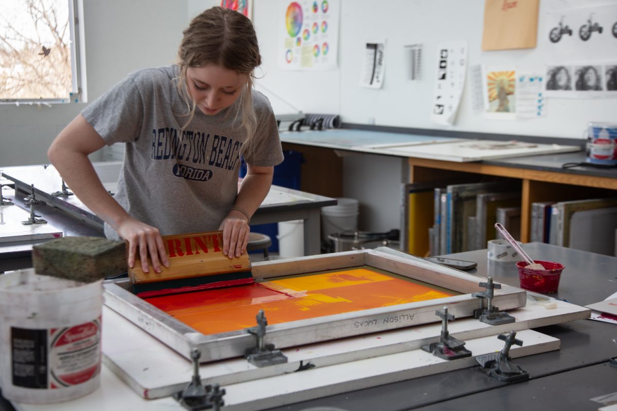 Allison Lucas, an undergraduate student, squeezes red ink on a silk screen in the Visual Art Building, Iowa City, Iowa, on Wednesday, April 15, 2026. (Sal Yang/The Daily Iowan)