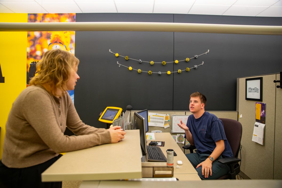 Kelsey Ryder talks to Eli, a student who works the front desk at the University of Iowa on Monday, May 1, 2026. Ryder is the senior associate director for the office of financial aid located at the University Capitol Centre in Iowa City, Iowa. (Sarah Hughes / The Daily Iowan)