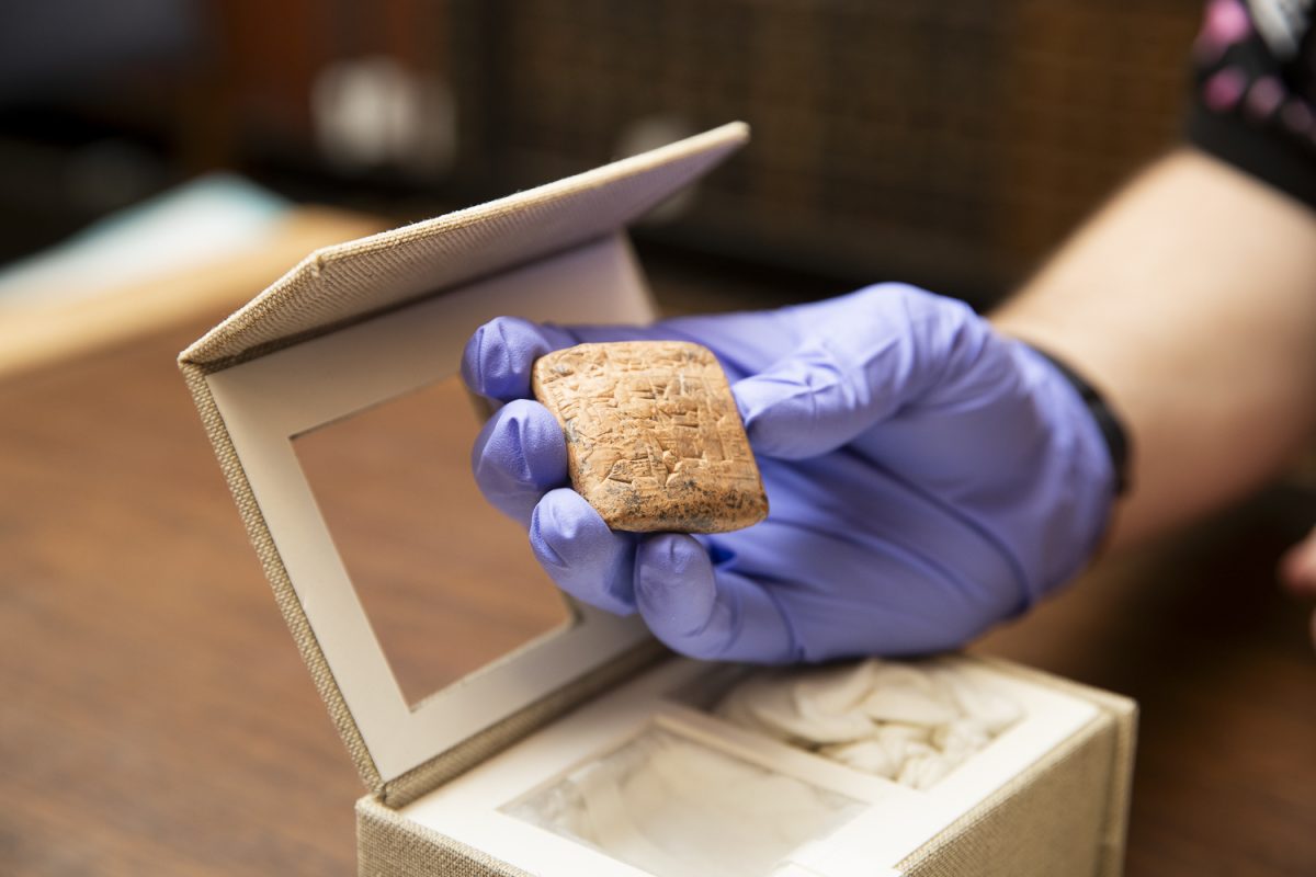 Noah Jedlicka displays one a text engraved in stone in the special archives of he University of Iowa Main Library in Iowa City on Wednesday, May 5, 2026. The text is one of the oldest books found in the archives. (Ethan McLaughlin/The Daily Iowan)