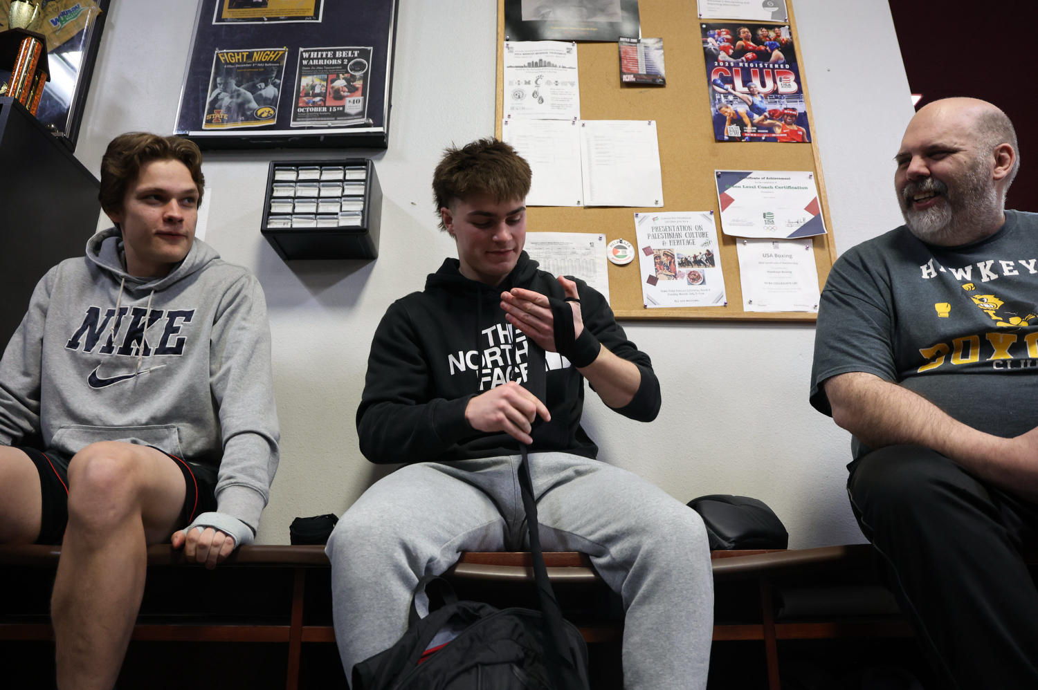 Kasey Hemann, Samson Diener, and George Chamberlin sits on a bench before training on Tuesday, March 3, 2026.